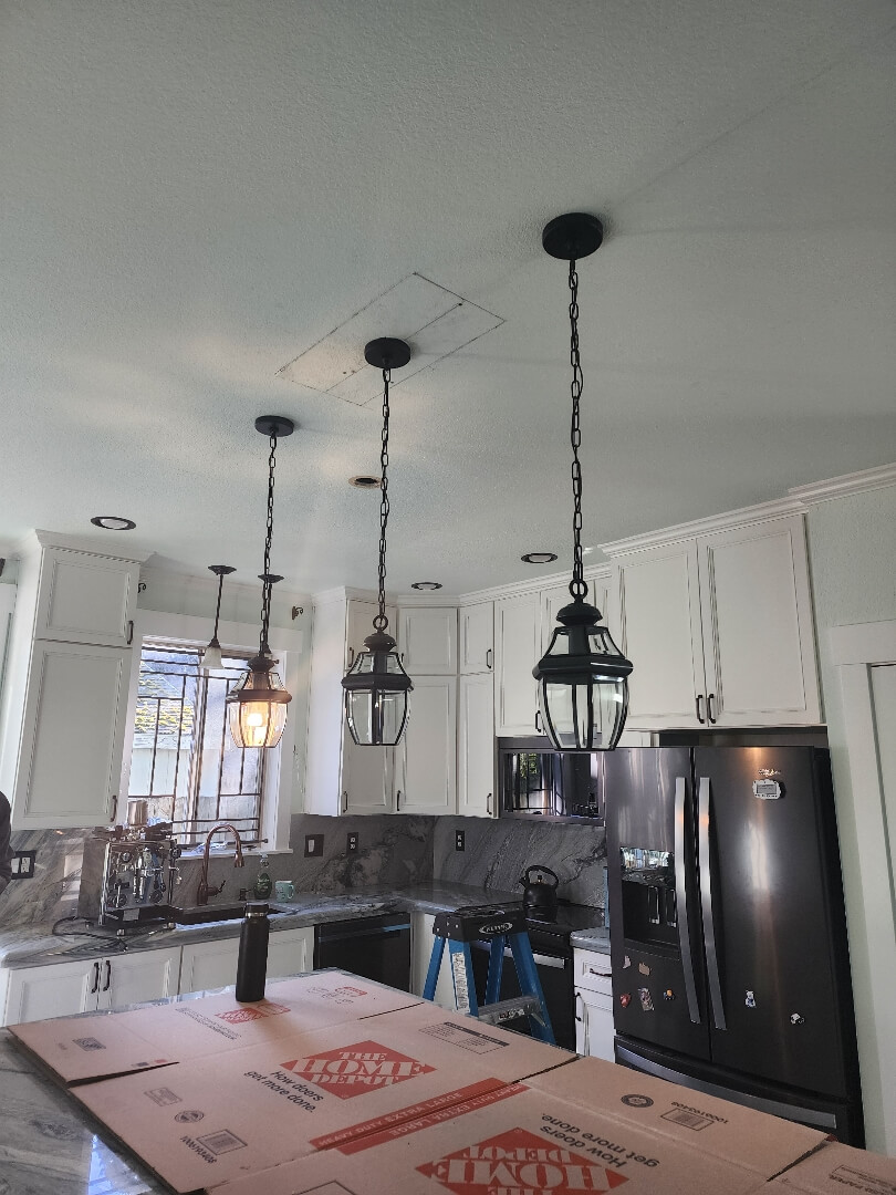 Kitchen island with pendant lights installed above countertop in modern open-concept kitchen