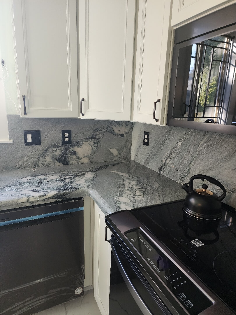 Modern kitchen backsplash with multiple electrical outlets installed above countertop near stove and sink