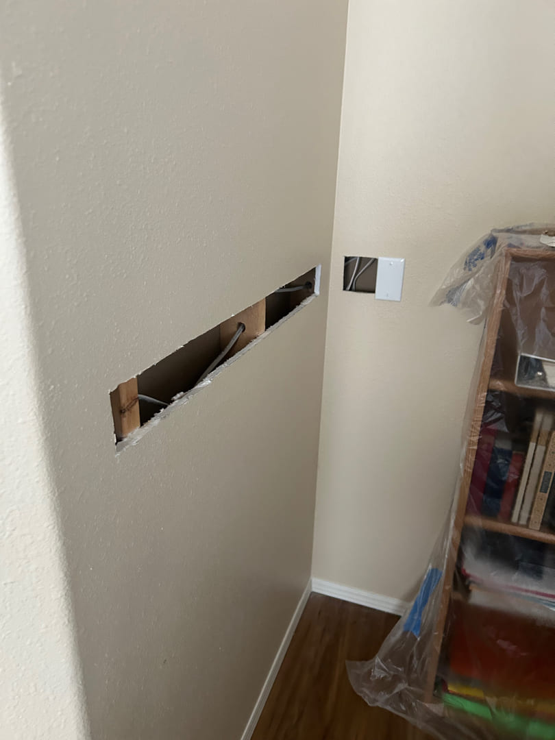 Wall cutout for electrical wiring and outlet relocation during home renovation