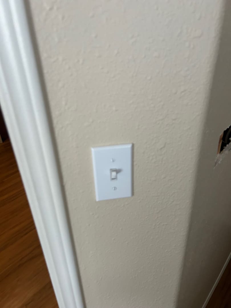 Newly installed light switch on interior wall near doorway with clean finish