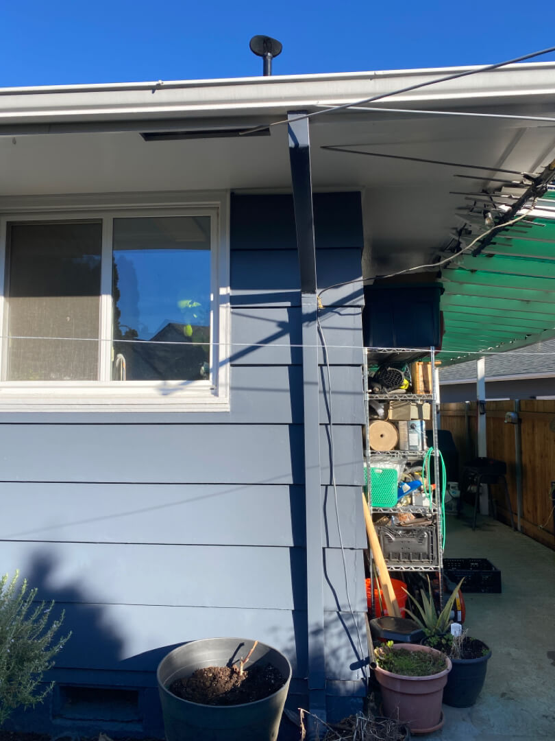 Exterior electrical meter and panel with vertical conduit installed on home siding near outdoor area