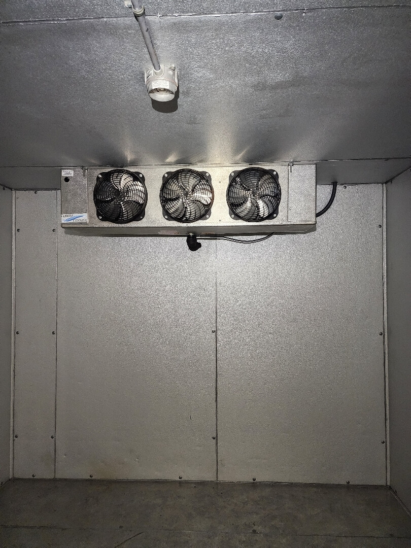 Walk-in freezer interior with evaporator fans and ceiling light powered by commercial electrical installation in Portland OR