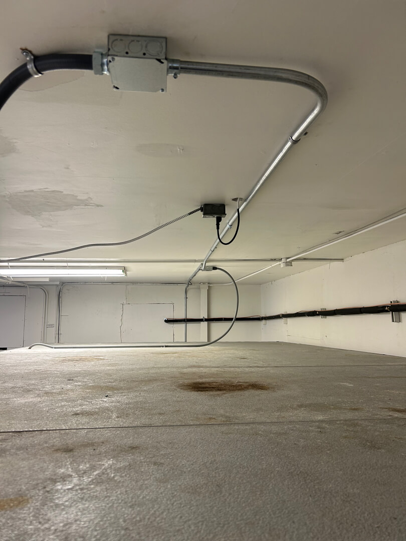 Ceiling-mounted conduit and junction box supplying power to walk-in freezer unit in commercial space Portland OR