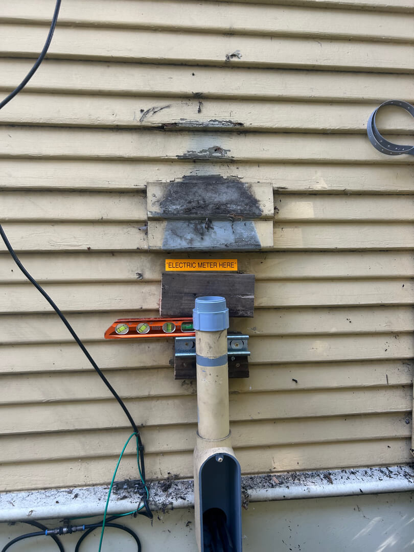 Repaired service mast and meter base with updated conduit and secure mounting on exterior wall in Portland