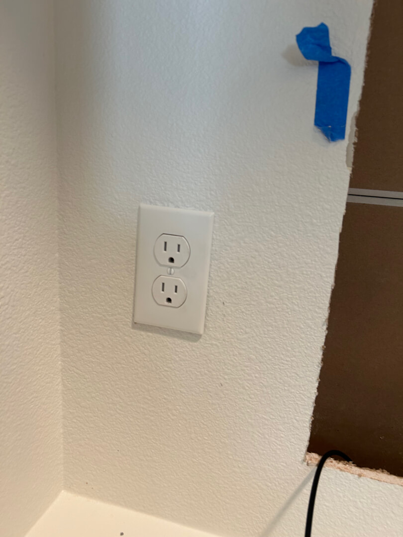 Finished electrical outlet installed inside closet wall with clean cover plate in Portland OR
