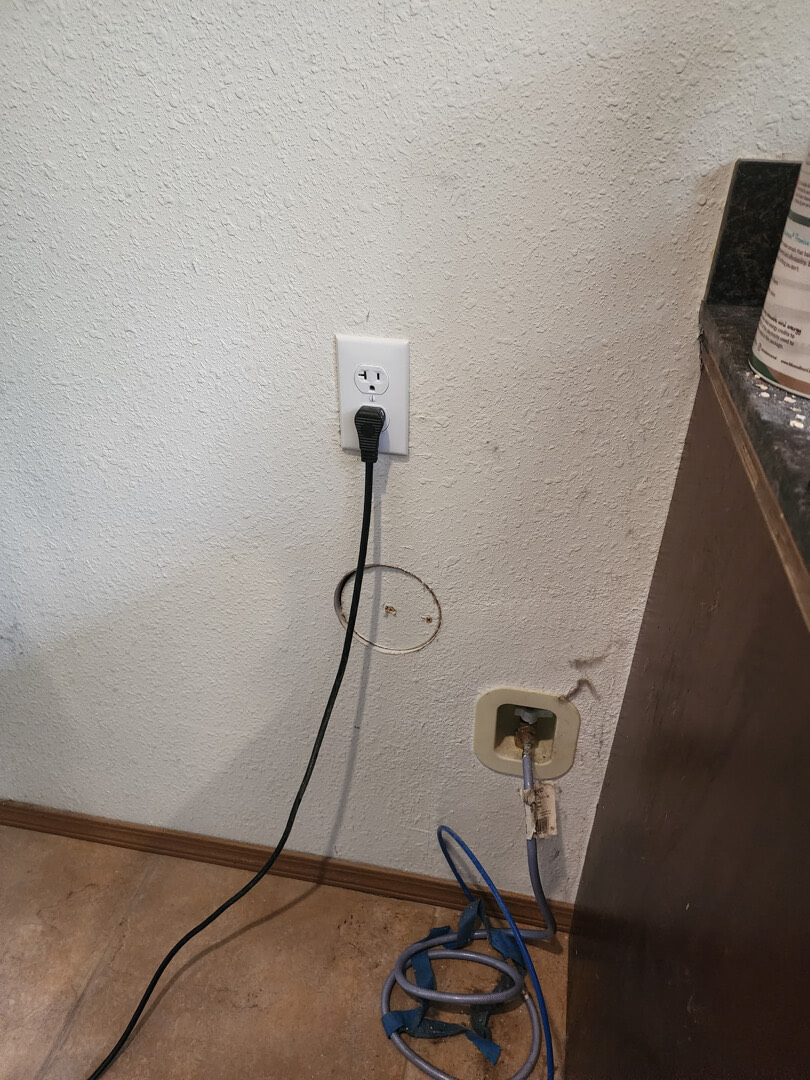 New wall outlet installed near floor powering appliance with dedicated 20-amp circuit in Portland OR
