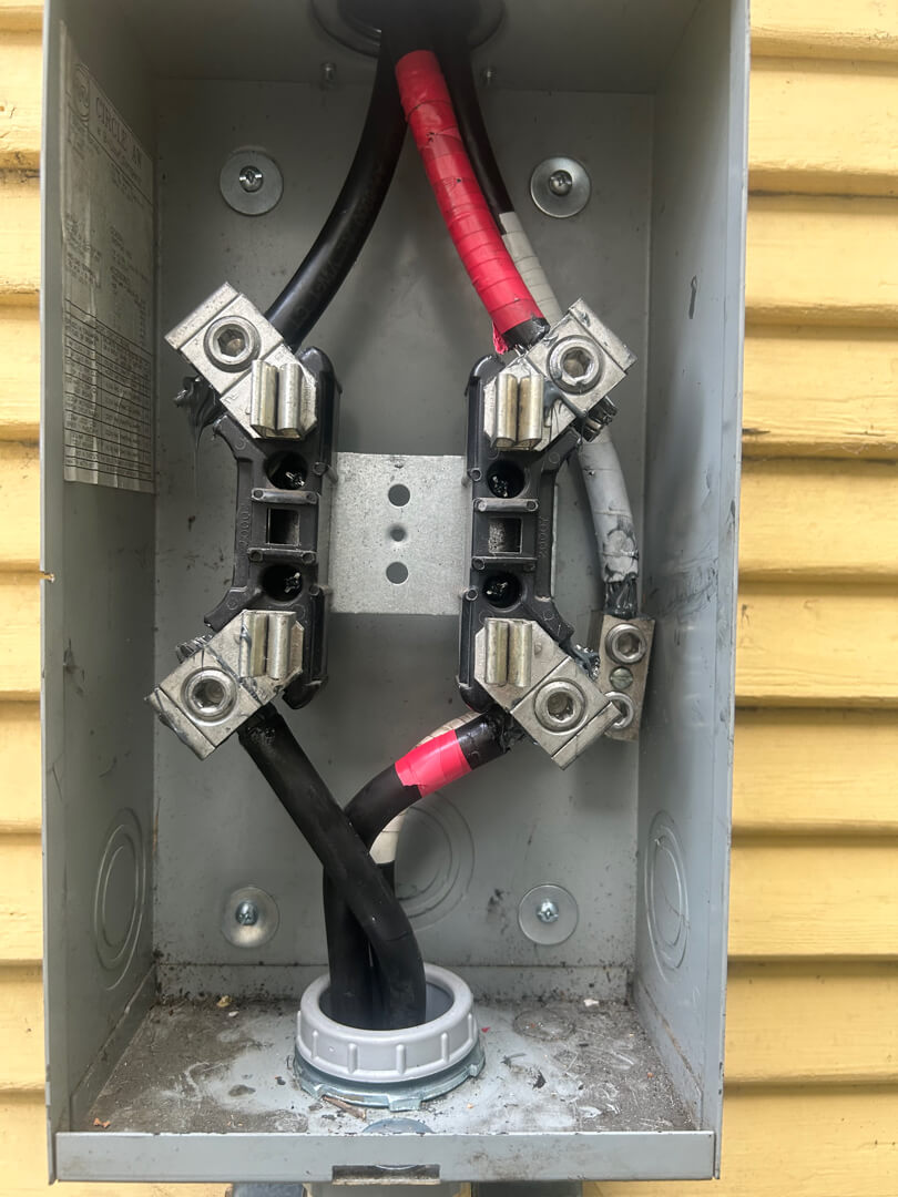 Meter base interior with new electrical connections and service conductors installed in Portland OR