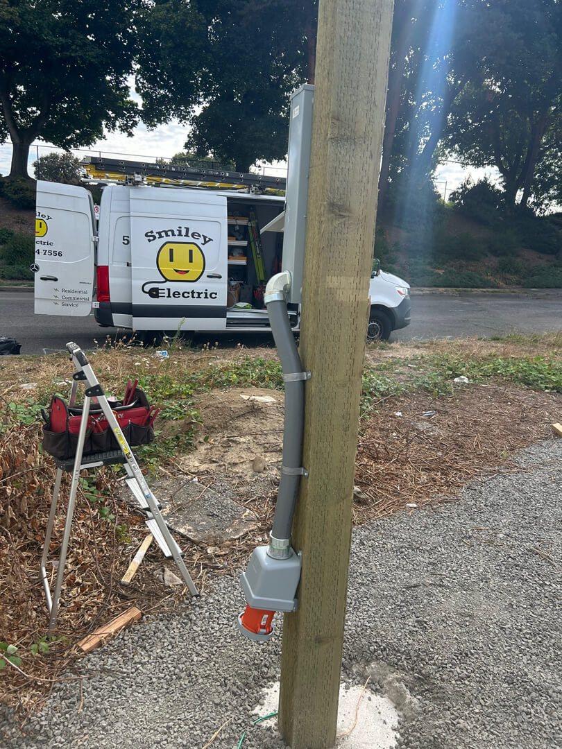 Temporary electrical service pole with meter and wiring setup near trailer site in Portland OR