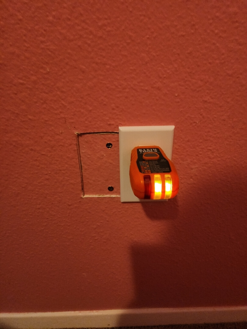 Newly installed 20-amp outlet in use with device plugged in on interior wall in Beaverton OR