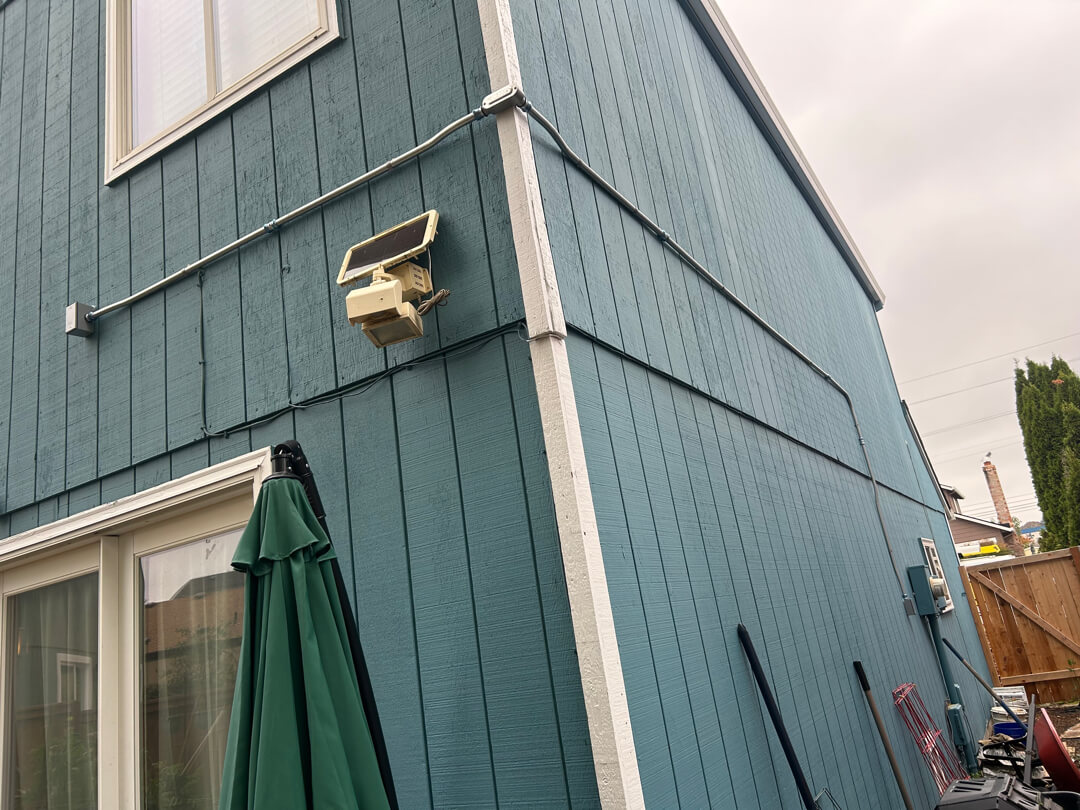 Exterior conduit running vertically along house siding for 20-amp circuit installation in Beaverton OR