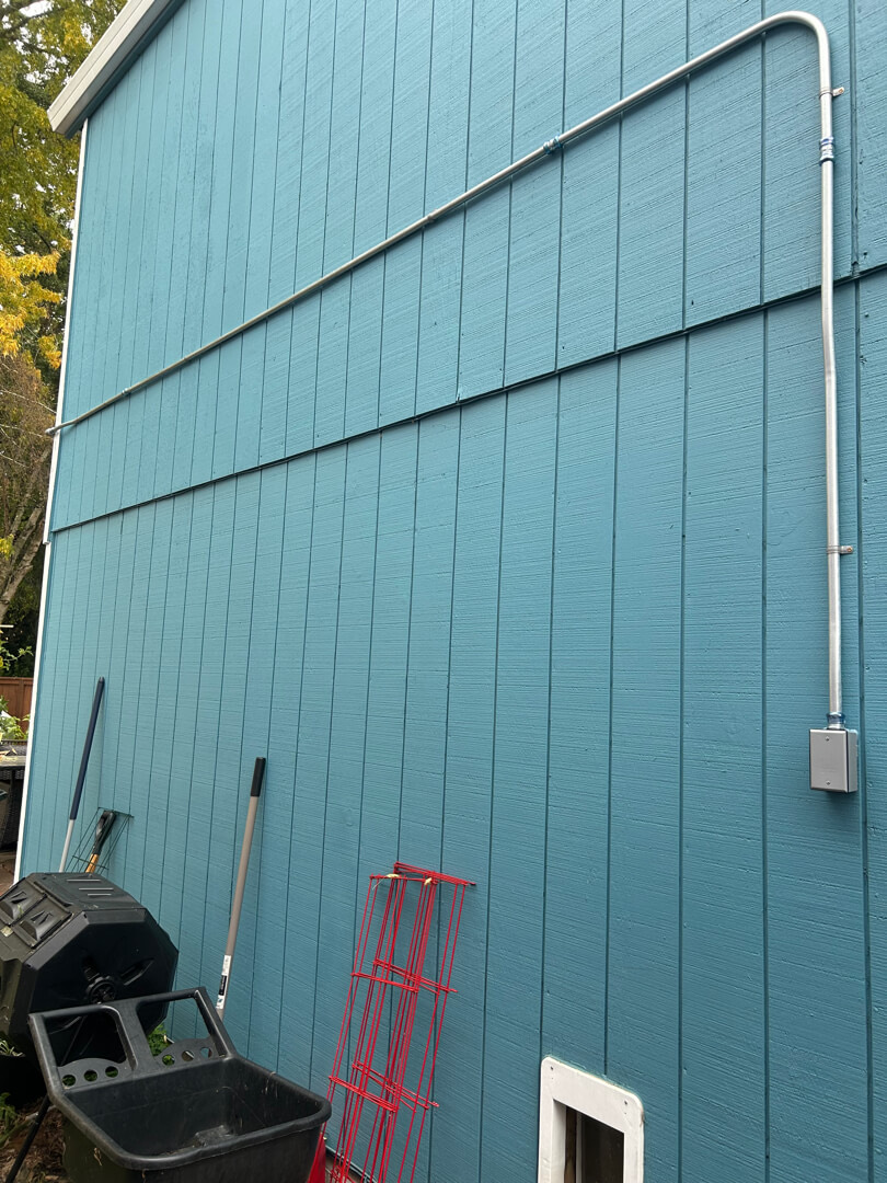 Exterior wall with extended conduit run and junction box for 20-amp circuit installation in Beaverton OR