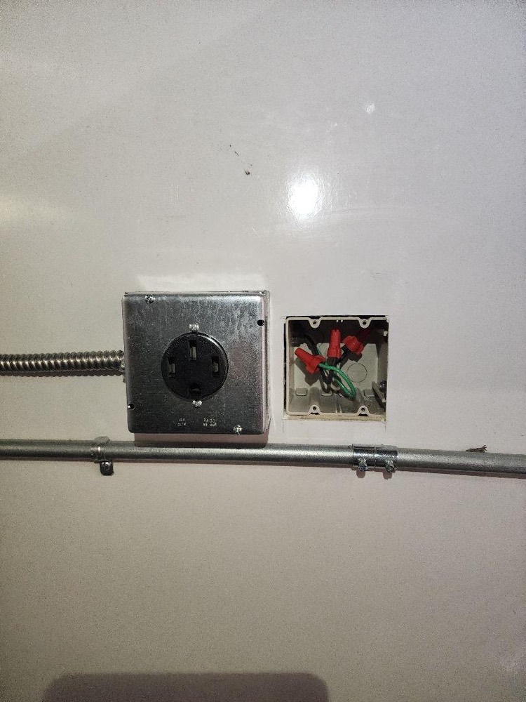 New 50-amp receptacle box and the junction box installed alongside it, fed with MC cable