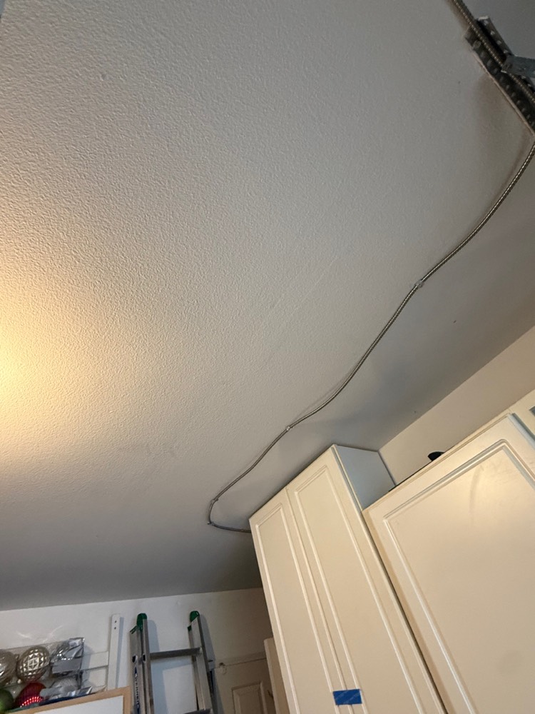 Armored cable routed along the kitchen ceiling to the refrigerator location