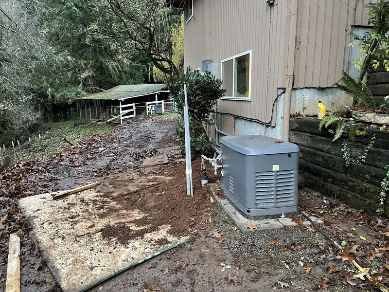 A standby backup generator installed on a pad beside a home.