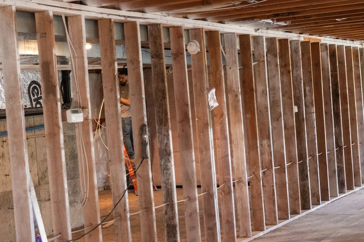 A Smiley Electric electrician wiring a Portland home mid-remodel.